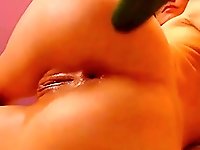 Webcam girl fucks her ass and pussy with a cucumber, gaping her loose ass.